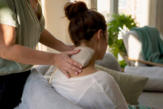 Hands applying warm compress to neck
