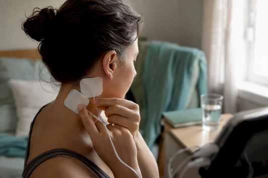 Hands placing electrode pads on neck