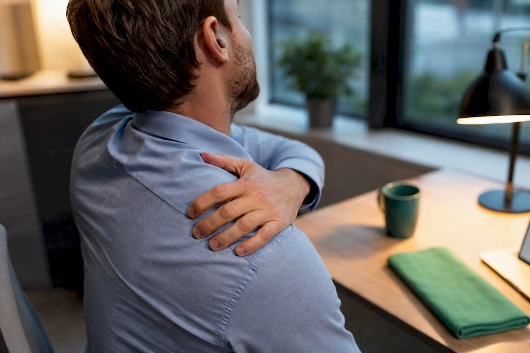 Professional massaging tense neck at desk